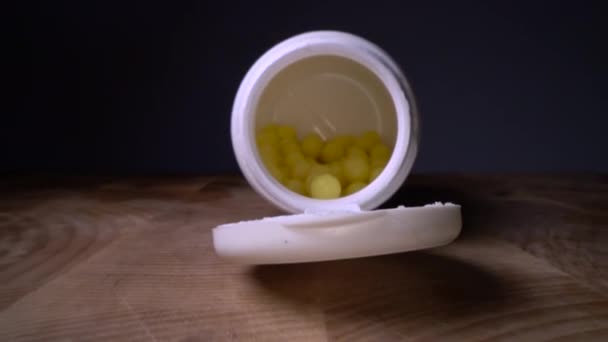 木製のテーブルの背景にボトルの隣に白い錠剤やカプセル 薬物処方 治療薬 医薬品の医薬品 健康のための容器の中の治療 鎮痛剤 うつ病 — ストック動画