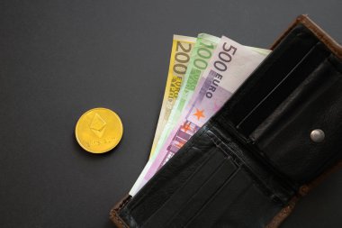 Ethereum sikke siyah arka plan üzerinde bir cüzdan dışarı yapışmasını Euro banknotlar yanında. Dijital para birimi, blok zinciri piyasası. Kripto sikke yanında Euro faturaları