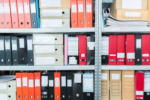 Kleurrijke blanco blinde mappen met bestanden in de kast. Archival, stapels documenten op kantoor of in de bibliotheek. Opslageenheden voor fysieke documenten — Stockfoto