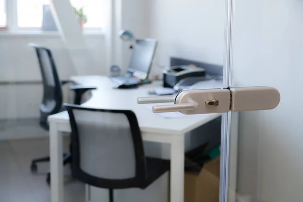 Modern, contemporary glass door lock handle with modern business office in the background. — Stock Photo, Image