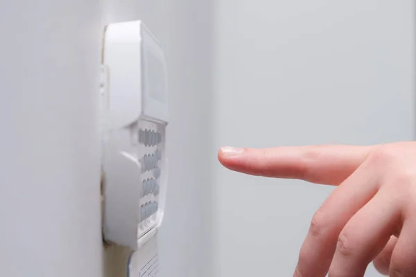 Женщина вручную вводит пароль системы сигнализации квартиры, дома бизнес-офиса. Наблюдение и защита от резины и воров — стоковое фото