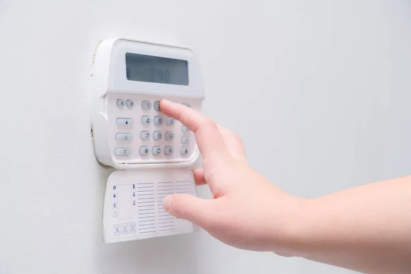 Woman hand entering alarm system password of an apartment, house of business office. Surveillance and protection console against rubbery and thief — Stock Photo, Image