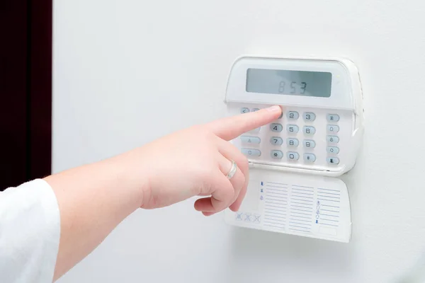 Mulher mão entrando senha do sistema de alarme de um apartamento, casa de escritório de negócios. Consola de vigilância e proteção contra borrachas e ladrões — Fotografia de Stock