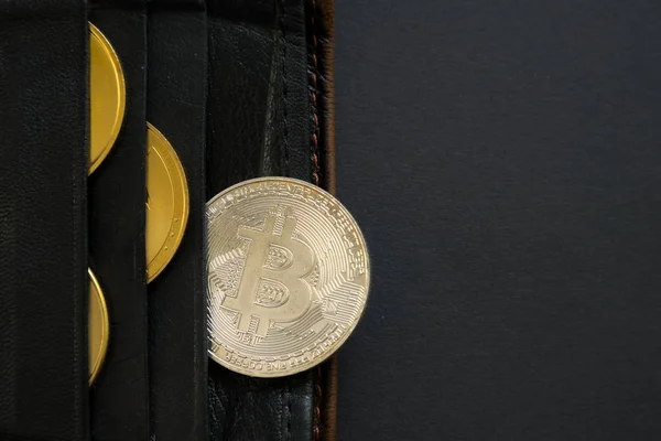 Bitcoin ragt aus einer Brieftasche mit schwarzem Hintergrund. Digitalwährung, Blockchain-Markt. — Stockfoto