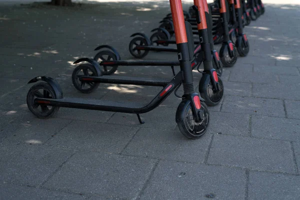 Moderni scooter elettrici eco città in affitto all'aperto sul marciapiede. Turismo alternativo, trasporti in città, servizio di sostituzione bici. E-scooter possono essere noleggiati con un'app — Foto Stock