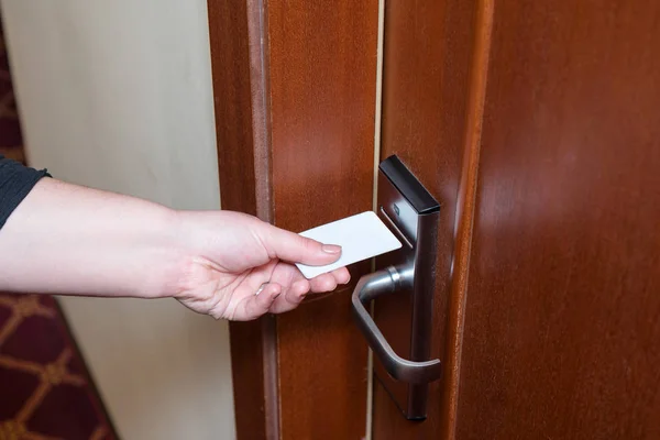 Female hand putting key card switch in to open hotel room door. — Stock Photo, Image
