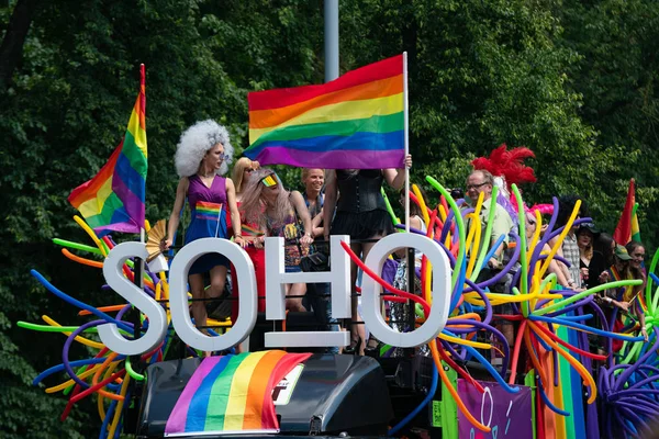 ВИЛНИУС, ЛИТУАНИЯ - 8 июня 2019 года: автобус SOHO с трансвеститами на мероприятии Baltic Pride, мужчины, одетые как женщины на гей-параде с радужным флагом на заднем плане — стоковое фото