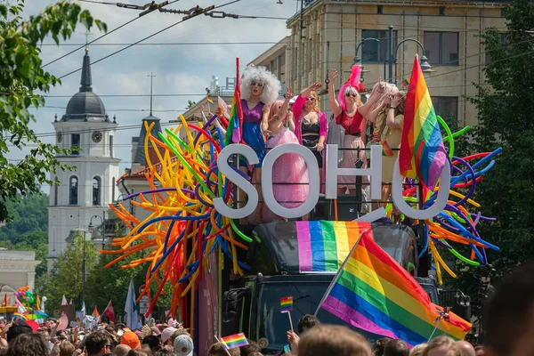 Vilnius, Litauen - 8. Juni 2019: Soho-Bus mit Drag Queens beim Baltic Pride Event, als Frau verkleidete Männer auf der Schwulenparade-Demonstration mit Regenbogenfahne im Hintergrund — Stockfoto