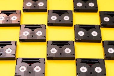 Eski Mini DV kaset bantları bir gün içinde geri filme için kullanılır. Sarı arka planda plastik video bantlar yapılmış deseni
