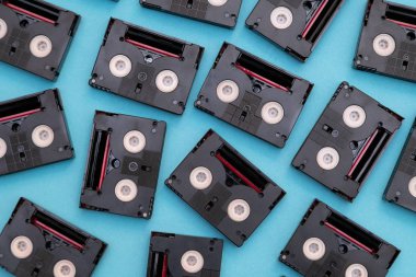 Vintage mini Dv kasetleri bir gün içinde geri filme için kullanılır. Mavi arka plan üzerinde plastik video bantları yapılmış rasgele desen