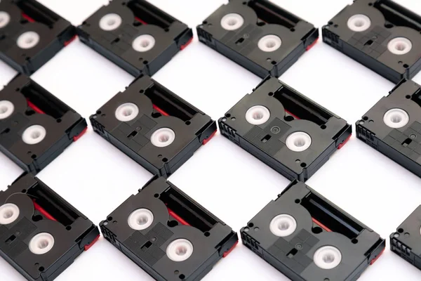 Cintas de cassette mini DV vintage utilizadas para filmar en un día. Patrón hecho de cintas de vídeo de plástico sobre fondo blanco —  Fotos de Stock