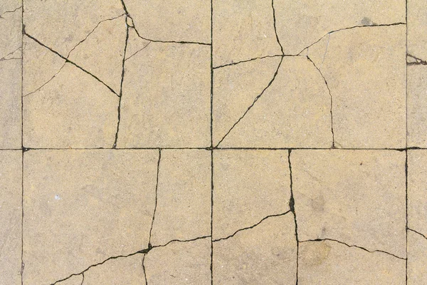 Cracked concrete tile texture. City pavement crack background. Abstract stone brick pattern. Street sidewalk texture.