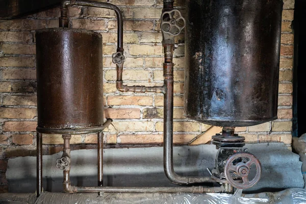 Rusty boiler room pipes. Old metal boiler generating heating and delivering it to home through pipeline. Hot water or gas is being delivered with this system