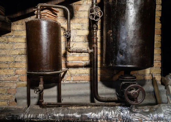 Rusty boiler room pipes. Old metal boiler generating heating and delivering it to home through pipeline. Hot water or gas is being delivered with this system