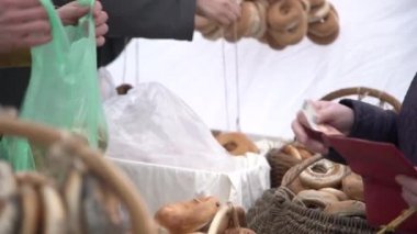 Müşteri satın alma halka şeklinde ekmek rulo haşhaş tohumu ile bir şehir ücret terbiyeli. Simit, ekmek halkası için el ödeme para