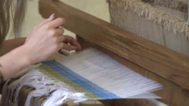 Tezgah üzerinde mavi ve beyaz desen dokuma kadın elleri yakın. Geleneksel dokuma tekniği