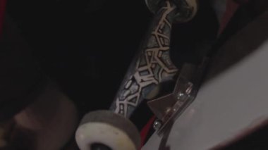 Skateboarder setting up his board, screwing bolts on the truck. Mans hands assembling skateboard - board, wheel, trucks, bearings