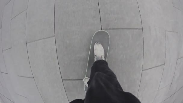 街の歩道でスケートボードに乗るスケートボーダーの視点 都市環境でフリースタイルを転がすスケーター ボード上のバランスを保持する若い男 極端なスポーツ — ストック動画
