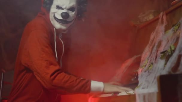 Невпізнаваний Чоловік Страшною Маскою Клоуна Хеллоуїна Грає Піаніно Містичним Туманом — стокове відео