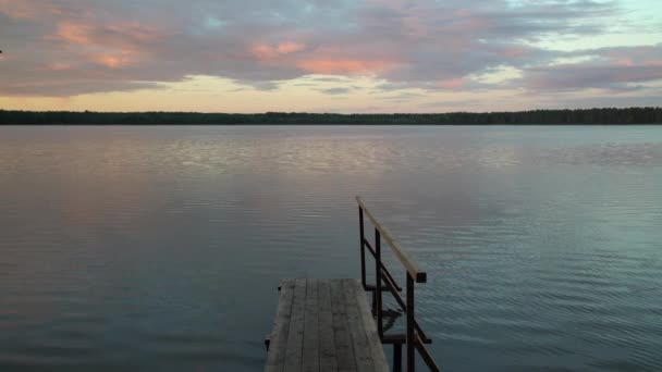 湖边的木制码头 以燃烧的日出天空和森林为背景 五颜六色的日落天空在水岸边 和平时期露营在自然 — 图库视频影像