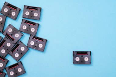 Vintage mini DV cassette tapes used for filming back in a day. Pattern made of plastic video tapes on blue background clipart