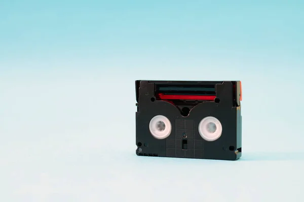 Cinta de casete mini DV vintage utilizada para grabar vídeo en un día. Cinta de plástico, magnética y analógica sobre fondo azul —  Fotos de Stock