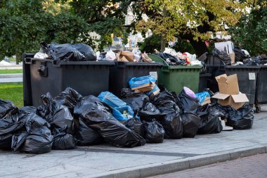 Şehir fuarından sonra çöpkonteynerinin yanında büyük çöp yığınları var. Bir şehirde festival den sonra çöp torbaları taşması çöp yığınları