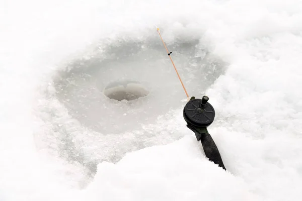 Pesca de invierno en el hielo. Un cebo en un agujero de hielo. Relajarse en la naturaleza —  Fotos de Stock