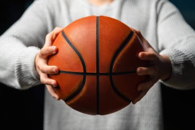 Profesyonel basketbolcunun elinde top tutmasına yakın çekim. Sokak basketbolcusu yarışmaya hazırlanıyor. Başarı kavramı, puanlar ve kazanma