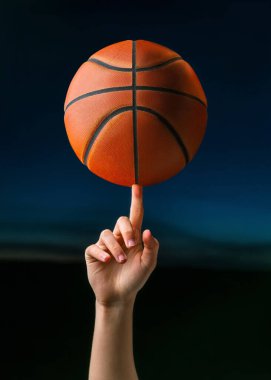 Profesyonel basketbolcunun el parmağında top çevirmesine yakın çekim. Sokak basketbolu müsabakaları için