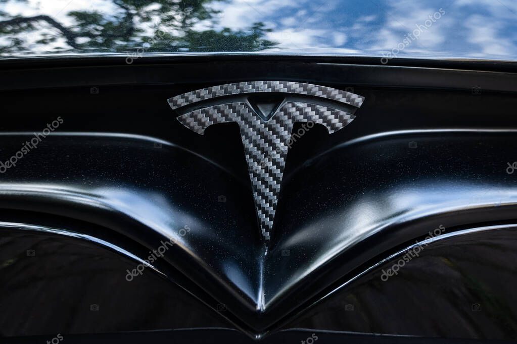 Prague, Czech Republic - June 2020: Tesla motors car badge logo dark background. Modern electric vehicle manufacturer.