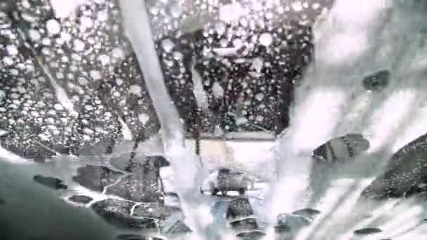 在输送机隧道洗车过程中 从车内近距离观察 洗车用肥皂和水 自动洗车用旋转刷子 — 图库视频影像