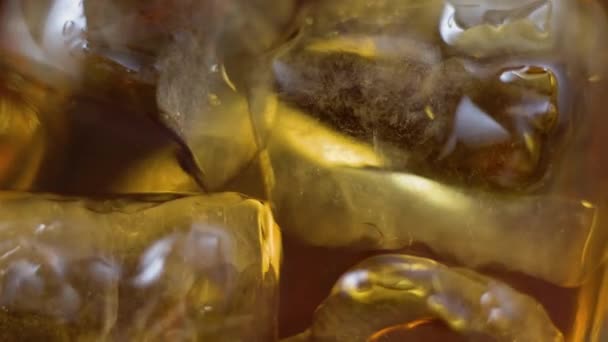 Macro Cubitos Hielo Flotando Vaso Whisky Dorado Envejecido Sobre Mesa — Vídeo de stock