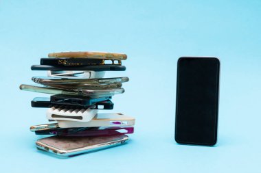 Mavi arka planda cep telefonu için çok renkli plastik kapaklar yığını. Akıllı telefon koruyucusu aksesuarları seçimi. Akıllı telefonun yanında bir sürü silikon telefon ya da deri var.