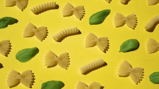 Uncooked Curly Pasta Basil Leaf Pattern Yellow Background Traditional Dry — Stock Video