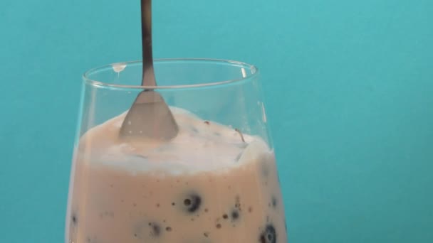 Zblízka záběr jíst jogurt s čerstvými borůvky ve sklenici. Zdravá snídaně