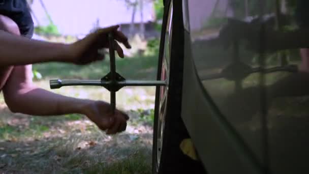 紧紧抓住男性的手 在外面换胎 把破车胎放在草地上 旅行意外 — 图库视频影像