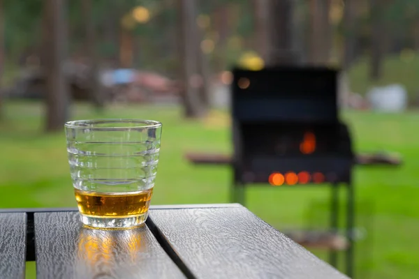 Szkło Whisky Drewnianym Stole Obok Płonącego Grilla Podwórku Napój Alkoholowy — Zdjęcie stockowe