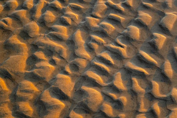 Sahildeki doğal kum tepecikleri oluşumunun soyut görüntüsü. Kıvırcık kum dalgası deseni yakın çekim. Güzel kumlu arka plan. Kimse.