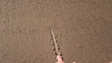 El yazısının kapanışı. Kumsaldaki kumlara imza atmanı seviyorum. Günbatımında tropik deniz kıyısında romantik aşk sembolü.