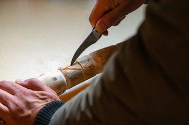 Karantina sırasında insanların odundan baston yapmaları. Bıçakla masaya odun kazımak.