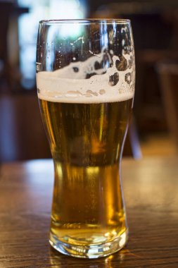 Bir bardaki masada bir bardak bira.