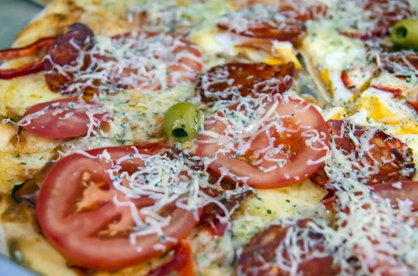 Dilimlenmiş domates ve peynirli taze pizzayı yakın plan çek.