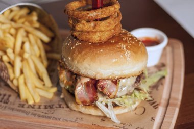 Pastırmalı hamburger, patates kızartması ve kalasta salata.