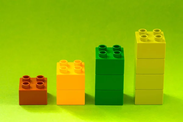 生长的条形图从绿色背景上的彩色玩具块 — 图库照片