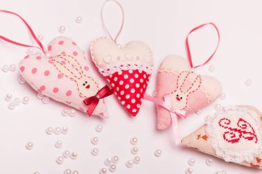 bir tavşan ve bir tebrik kartı için pembe bir arka plan üzerinde bir yay ile dört romantik güzel kalp