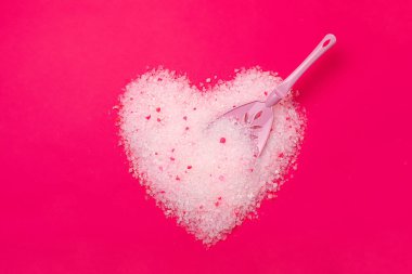 Cat litter, heart shaped bright pink background with a spatula for cleaning poop. Concept for labels, packaging advertising of the love of animal hosts to a neutralizing odor filler. clipart