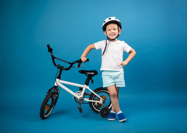 Ребенок Велосипедом Ребенка Защитном Шлеме Стоит Синем Фоне Смотрит Камеру Лицензионные Стоковые Изображения