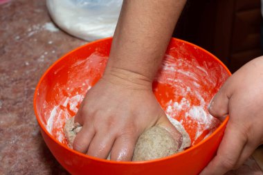 Bir adam büyük bir kasede ev yapımı ekmek hamuru yapar. Ev yapımı lezzetli pastalar için hamur işi..