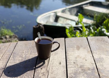 Çay kaşık ahşap arka plan, nehir ve tekne arkasında ile